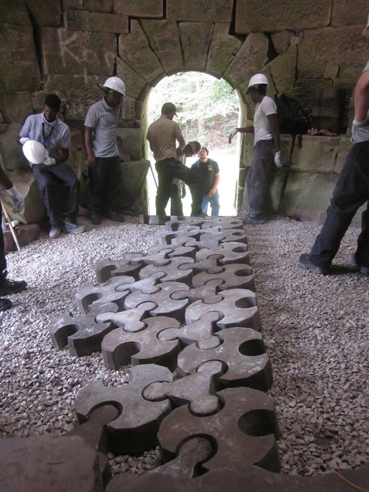 A group of employees works on the fitchburg furnace, an old structure part of the iron industry period of in eastern kentucky history.