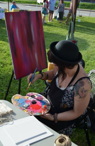 artist painting a red canvas at an event in hazard called thursdays on the triangle.