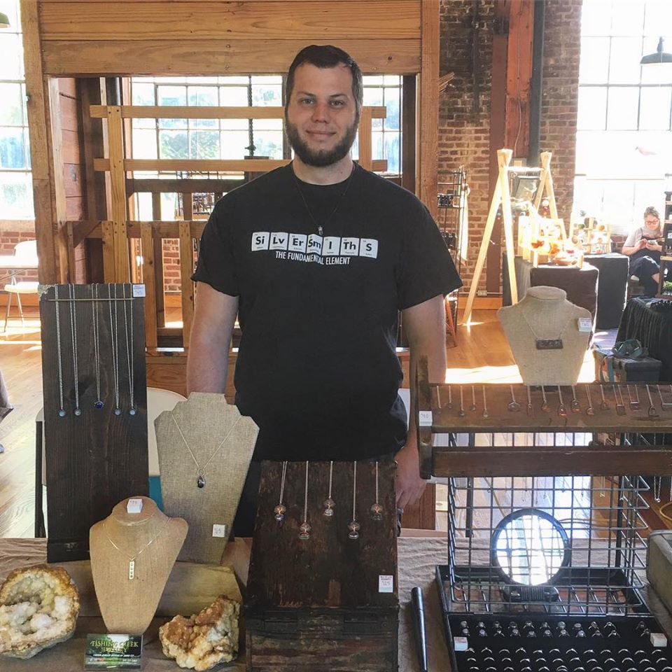 Jared stands with his display for Fishing Creek Jewelry, based in Somerset, Kentucky. MACED supports artists like Jared with loans