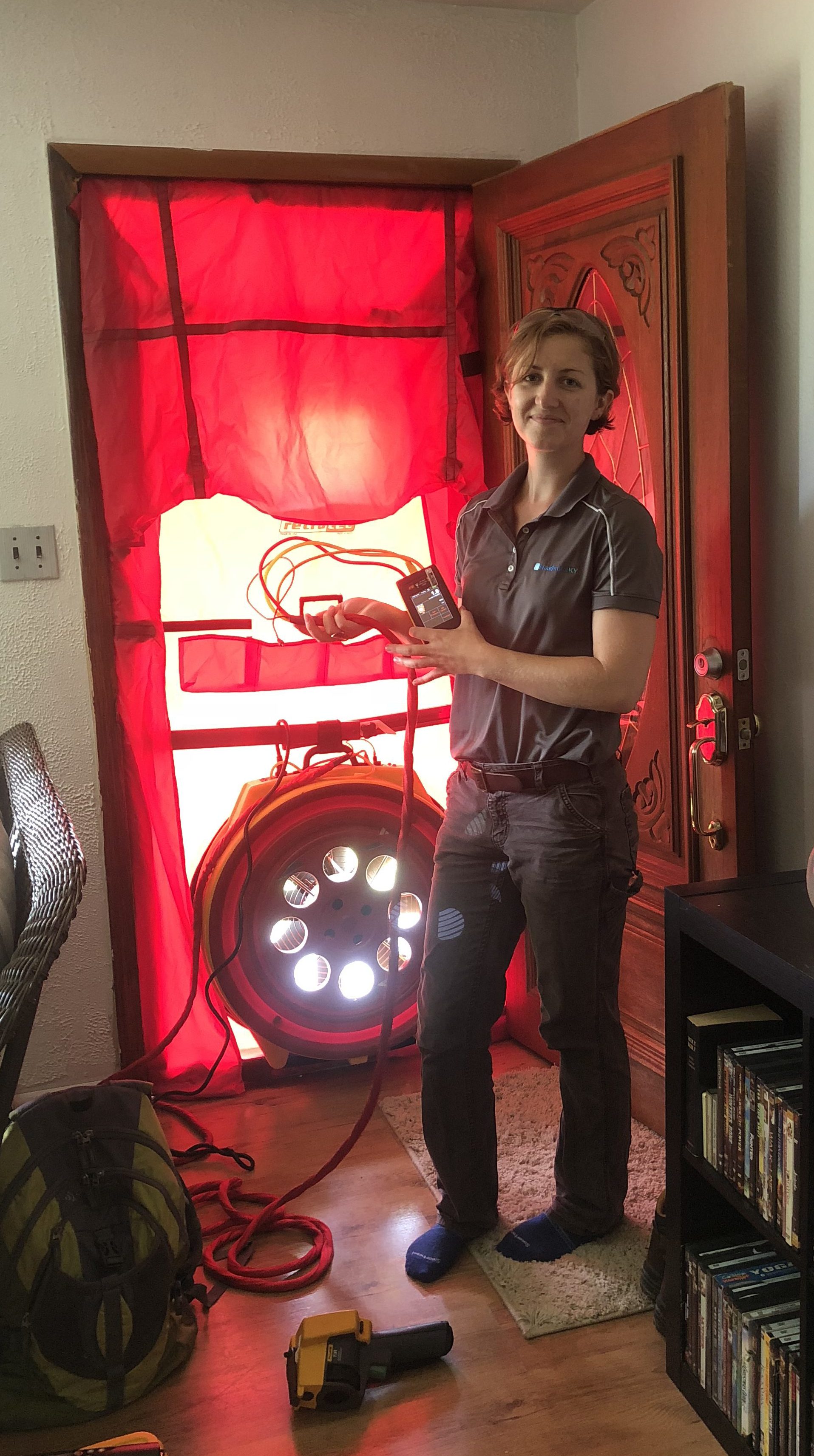 Woman stands in front of an energy efficiency equipment during a home audit in eastern kentucky.