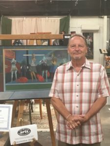 Dan click poses in front of an easel inside grayson art gallery in carter county, kentucky.