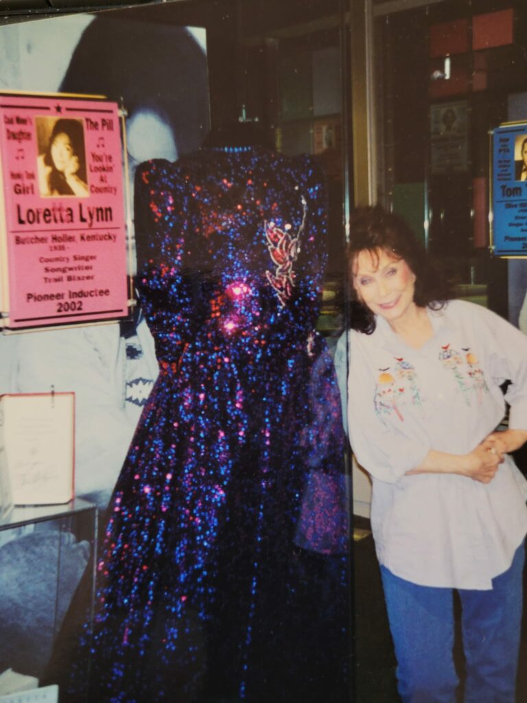 Loretta Lynn stands with a dress in her display at the Kentucky Music Hall of Fame.