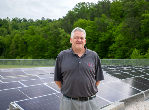 Larry stands in front of the solar installation